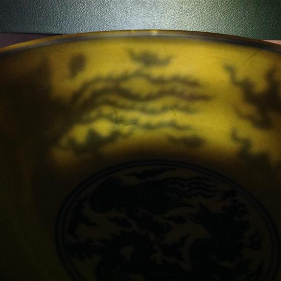 A Chinese yellow ground dragon and phoenix bowl, Xuande six character mark and possibly of the period, 19.5cm, museum restoration, sc